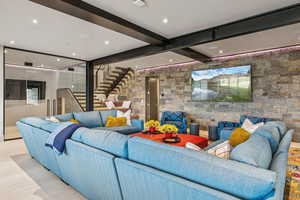 Tiled living area with stairs, beam ceiling, and recessed lighting