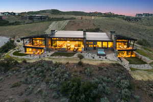 Rear view of house featuring a chimney, a patio, a standing seam roof, and a metal roof