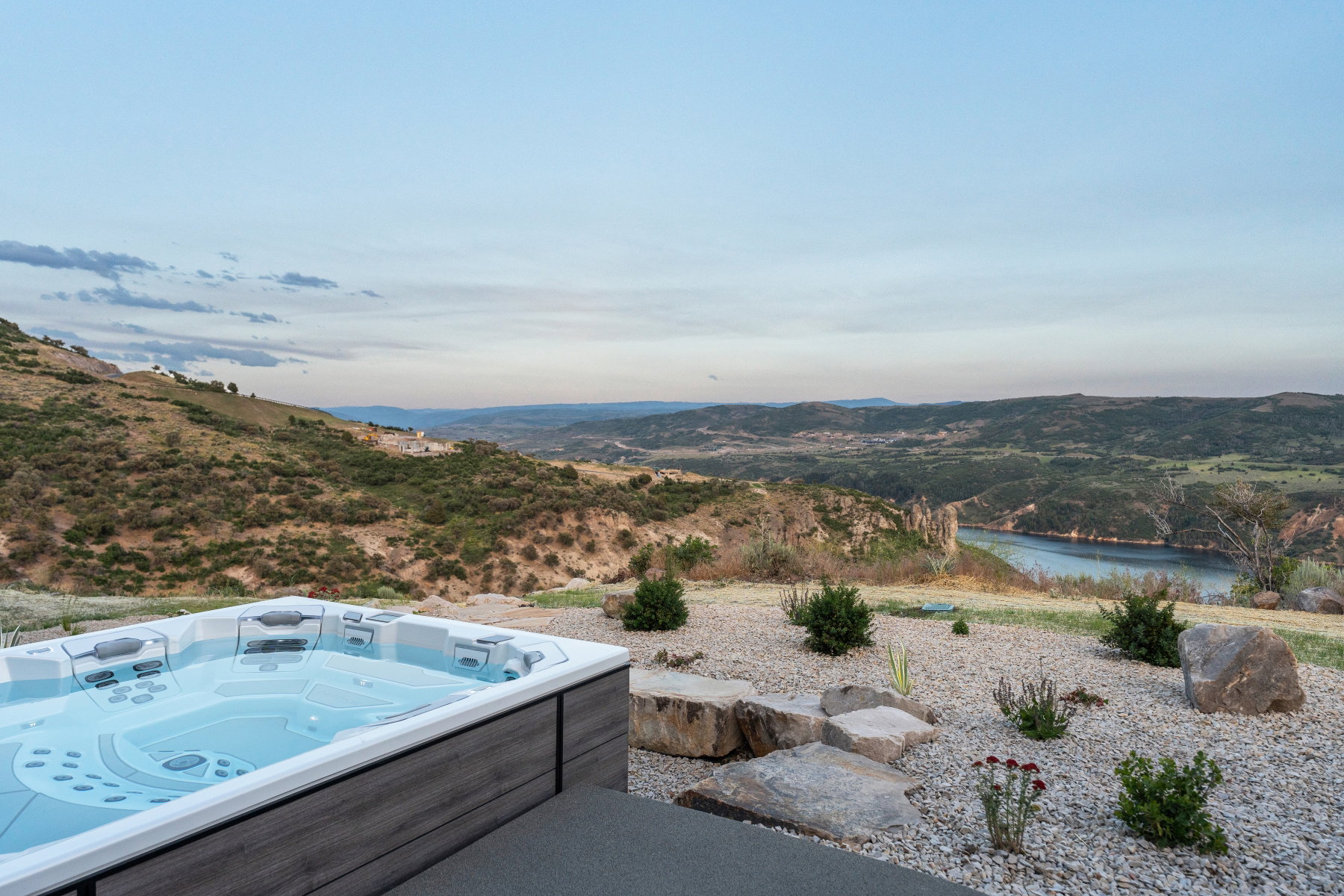 View of pool with a hot tub and a water and mountain view