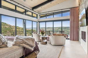 Bedroom featuring a mountain view, a wood ceiling with exposed beams, high vaulted ceiling, and tile patterned floors
