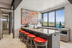 Indoor bar with light tile patterned flooring and recessed lighting