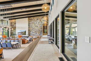 Hallway featuring beam ceiling and a high ceiling