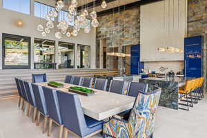Dining space featuring a towering ceiling, a chandelier, and beam ceiling