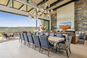 View of patio featuring outdoor dining space, a mountain view, and an outdoor living space with a fireplace