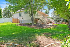 Back of property with a gate, stairway, and stucco siding