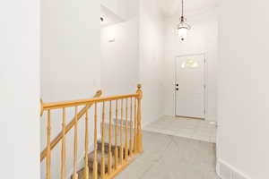Carpeted entrance foyer with tile patterned floors and a high ceiling