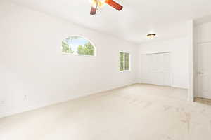 Unfurnished bedroom with light colored carpet, a closet, and ceiling fan