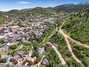 Aerial view of property and surrounding area featuring a mountainous background