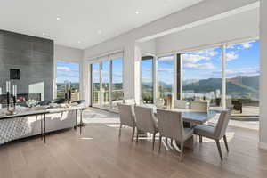 Dining room featuring a large fireplace, a mountain view, light wood-style floors, and recessed lighting
