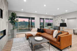 Living area featuring light wood-style flooring, a fireplace, recessed lighting, and a mountain view
