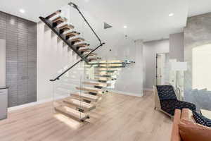 Stairs featuring wood finished floors and recessed lighting