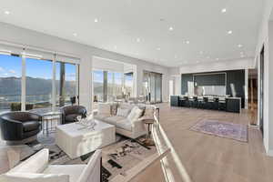 Living room with a mountain view, light wood-style floors, recessed lighting, and healthy amount of natural light