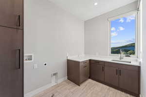 Laundry area with electric dryer hookup, hookup for a washing machine, cabinet space, and recessed lighting