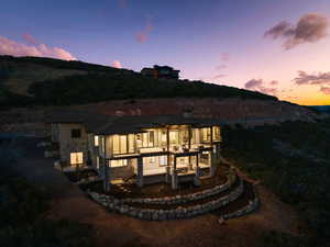 Back of property with a patio area and stone siding