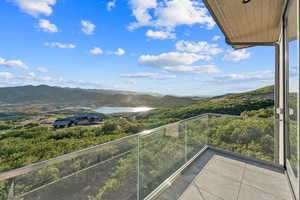 Balcony featuring a water and mountain view