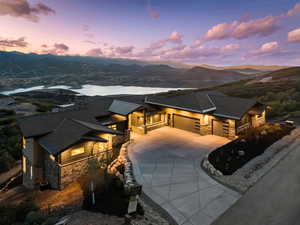 View of front of house with stone siding, an attached garage, driveway, and a mountain view