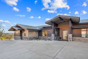 View of front of property featuring roof with shingles and stone siding