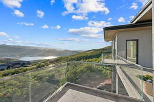 Balcony featuring a water and mountain view