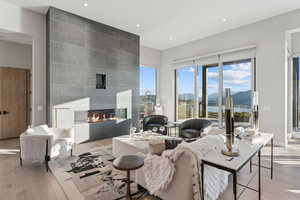 Living area featuring light wood-style flooring, a mountain view, a fireplace, and recessed lighting