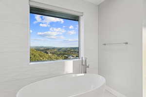 Full bathroom featuring a freestanding bath and tile walls