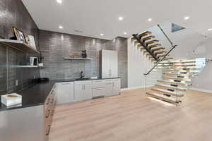 Kitchen featuring open shelves, dark countertops, recessed lighting, light wood-type flooring, and white cabinets