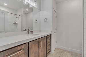 Full bathroom featuring vanity, a tile shower, and recessed lighting