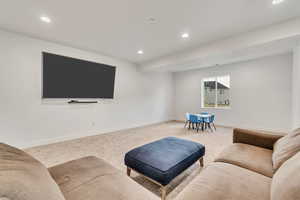 Carpeted living area with recessed lighting and baseboards