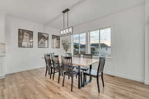 Dining room with light wood-type flooring and a chandelier