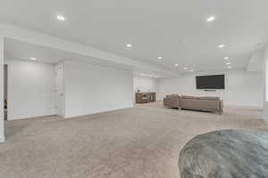 Living area with recessed lighting and light colored carpet