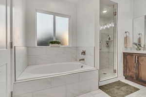 Full bathroom with a stall shower including 2 rain heads, a garden tub, vanity, and tile patterned floors