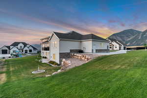 View of home's exterior featuring stucco siding, stone siding, a lawn, a playground, and a mountain view