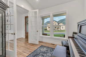 Living area with french doors, wood finished floors, and lofted ceiling