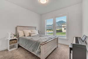 Bedroom featuring light carpet and a mountain view