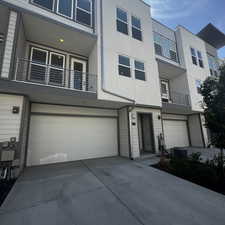Multi unit property featuring a garage, stucco siding, a balcony, and driveway