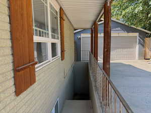 Exterior space with brick siding, an outbuilding, and a garage