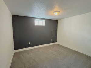 Carpeted spare room with baseboards and a textured ceiling