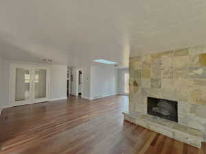 Unfurnished living room featuring wood finished floors and a fireplace