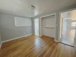 Unfurnished bedroom with a closet and wood finished floors
