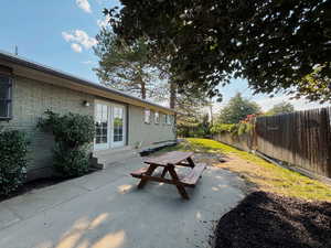 Fenced backyard featuring entry steps and a patio