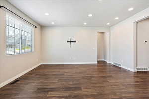 Spare room featuring dark wood-type flooring and recessed lighting