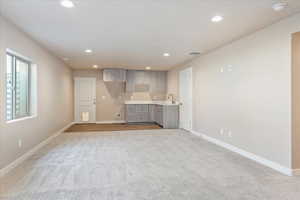 Unfurnished living room with light colored carpet and recessed lighting
