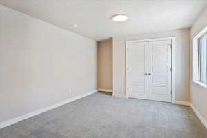 Unfurnished bedroom with carpet flooring and a closet