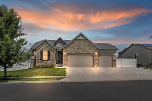 Craftsman-style house with stone siding, an attached garage, and concrete driveway