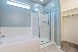 Full bathroom with a shower stall, a bath, and tile patterned floors