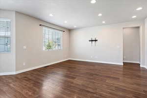 Unfurnished room with dark wood-style flooring, recessed lighting, and a textured ceiling