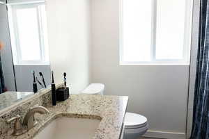 Full bath with healthy amount of natural light, vanity, and a shower with shower curtain