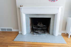 Detailed view of wood finished floors and a tile fireplace