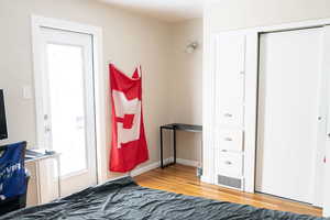 Bedroom with wood finished floors and a closet