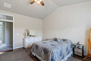 Bedroom featuring dark wood finished floors, vaulted ceiling, and ceiling fan
