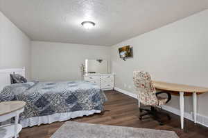 Bedroom featuring wood finished floors and a textured ceiling